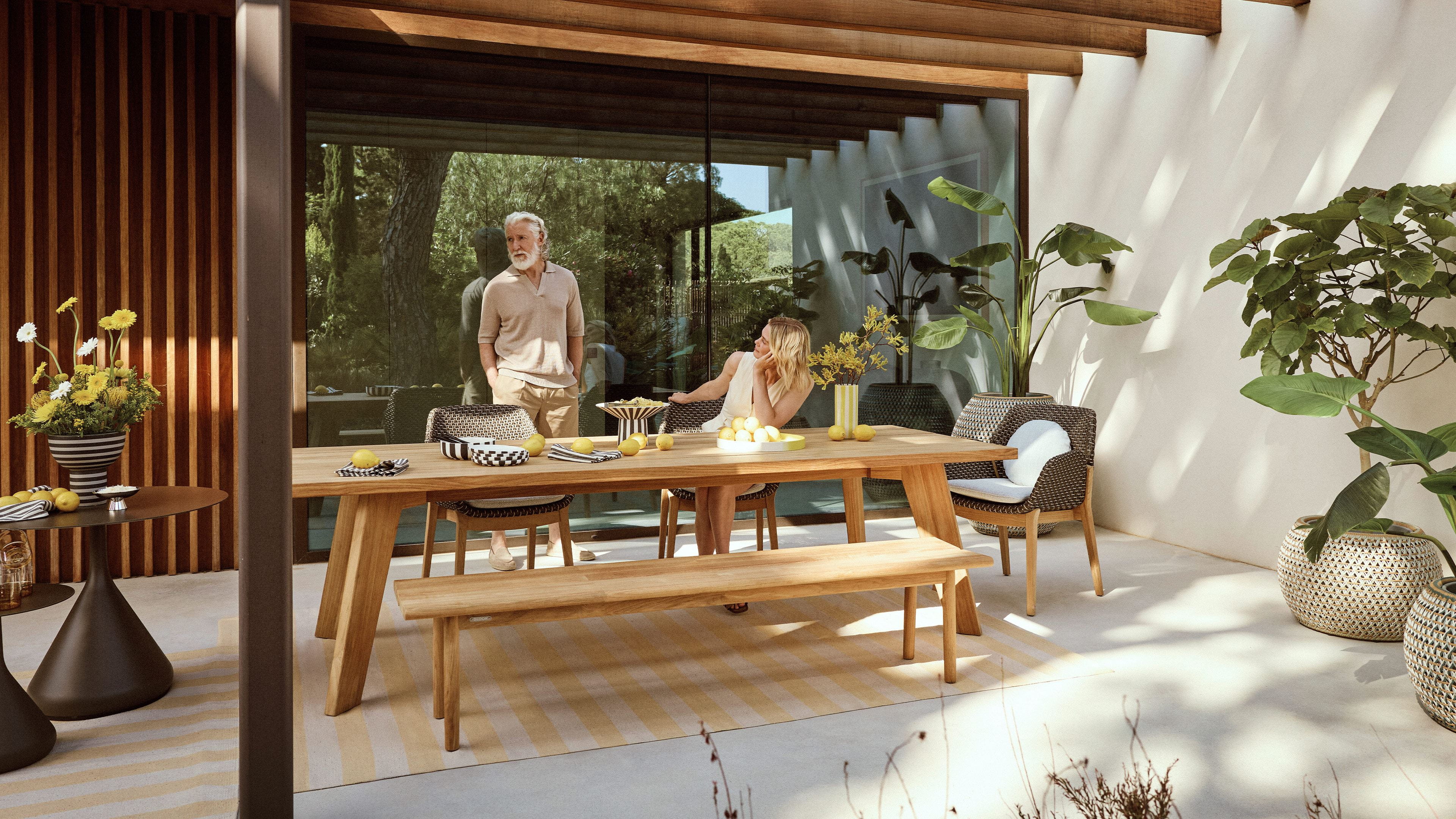 Dedon Caladio dining collection in an outdoor garden setting