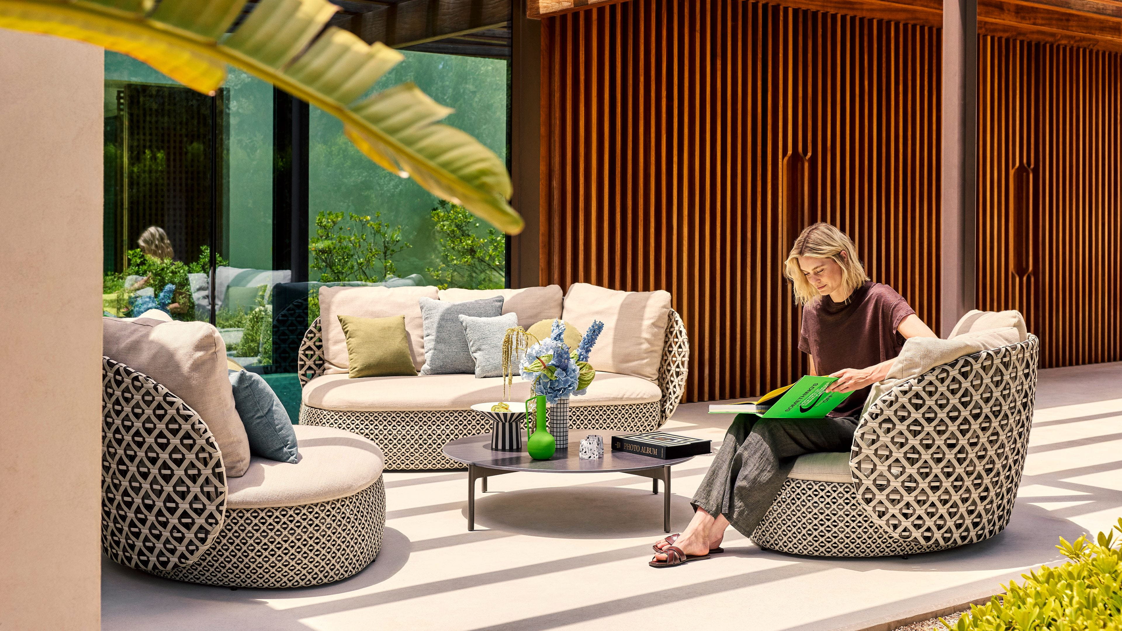 Dedon MDear collection lounge setting in a lush garden